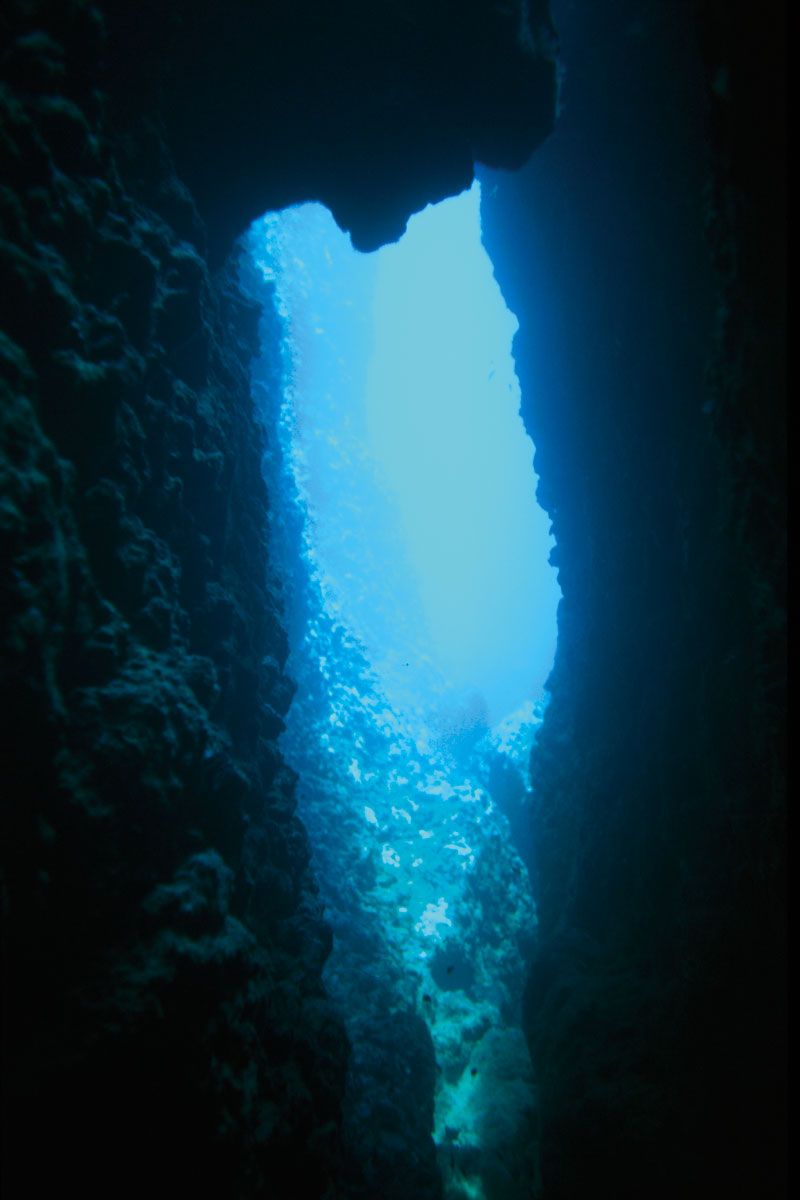 Figura 14: una situazione in cui il flash non avrebbe permesso di disegnare la silhouette della grotta. L’effetto di tunnel di luce è reso più intenso dalle pareti in primo piano quasi completamente nere. (Foto tratta dal libro Fotografia subacquea per turisti digitali)