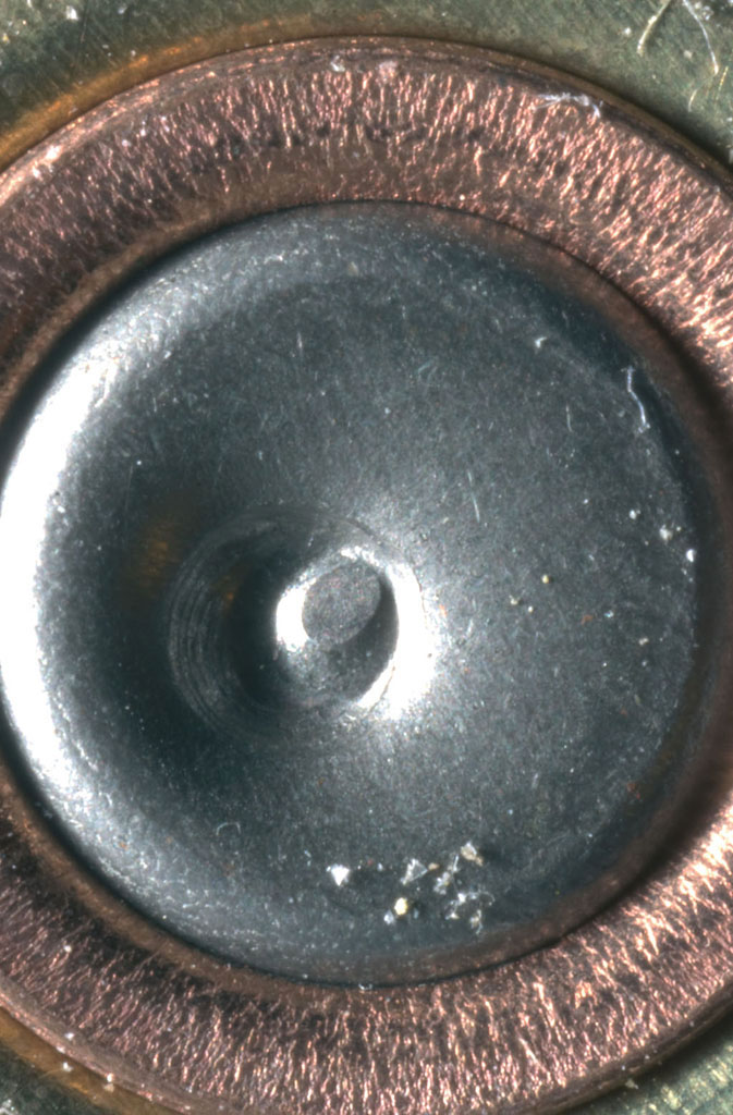 Figura 3: il segno che il percussore ha lasciato su questo bossolo è ben evidente e ha una forma ovale. È un esempio di come la macrofotografia sia utile in campo legale 